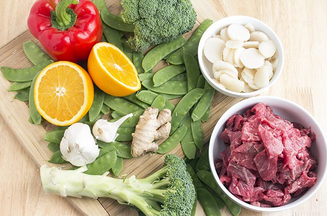 Ingredients for beef stir fry sitting on cutting board