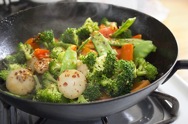 A large black wok filled with stir fry vegetables
