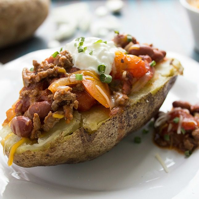 Healthier chili cheese baked potato on a white plate