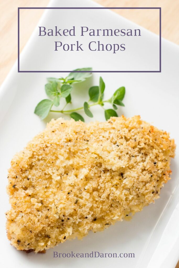 Parmesan pork chop on white plate with parsley