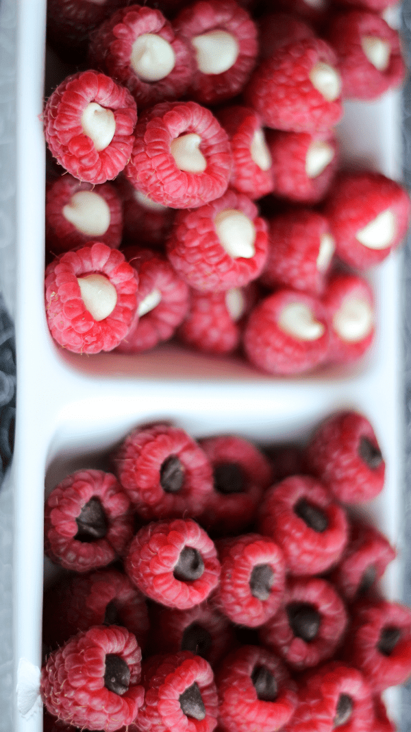 A white serving tray divided in two filled with chocolate raspberry poppers snacks