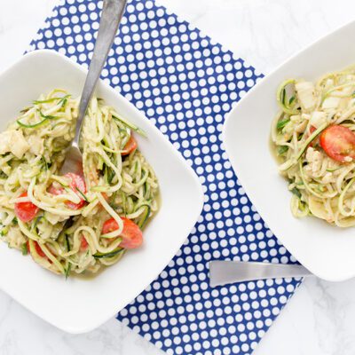 2 bowls of avocado pasta zoodles on white table