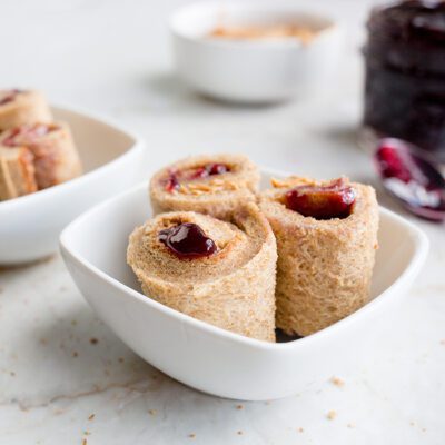Rolled peanut butter and jelly sandwich in white bowl