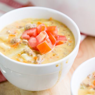 Up close small bowl of cheeseburger soup with chopped tomatoes