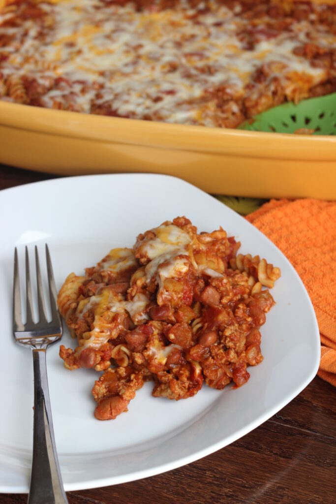 Longer picture of a serving of chili with macaroni and cheese