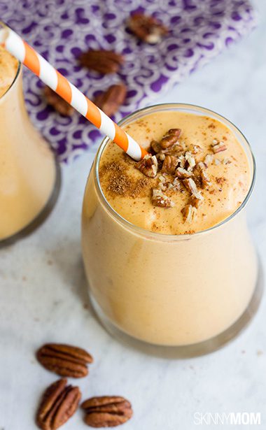 Overhead picture of glasses of pumpkin smoothie with purple napkin and pecans in background