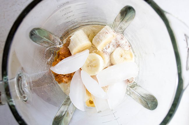 Overhead picture of blender filled with pumpkin smoothie ingredients