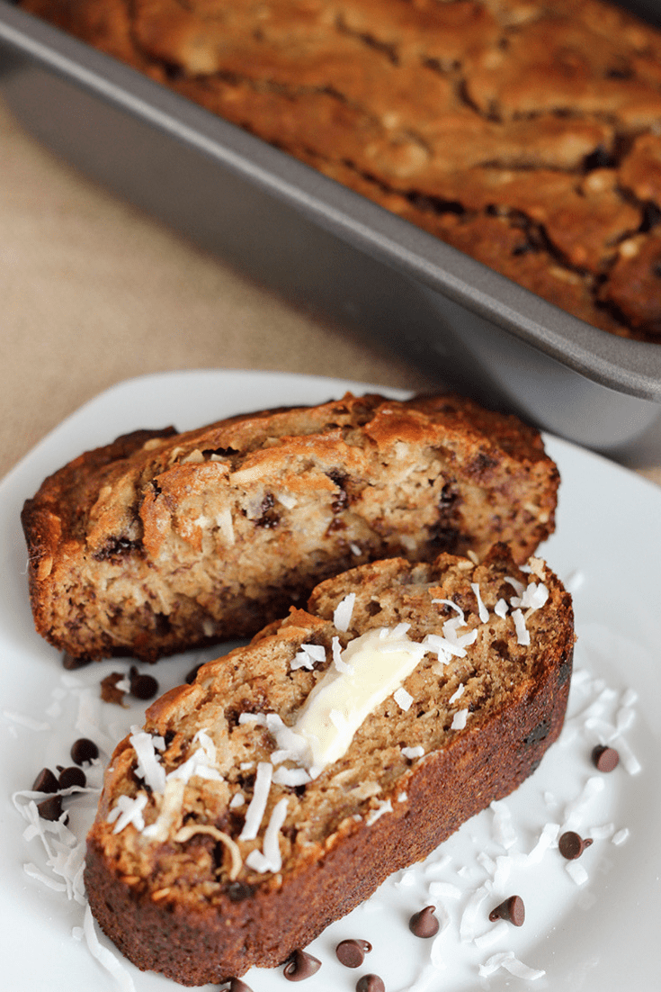 Sliced banana bread with coconut and chocolate chips on a white plate