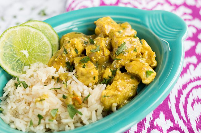 Thai chicken curry in a teal serving dish alongside rice