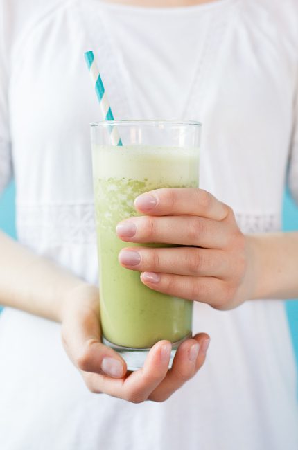 Woman in white dress holding glass of smoothie