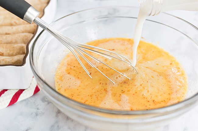 mixing eggs for overnight breakfast enchilada casserole