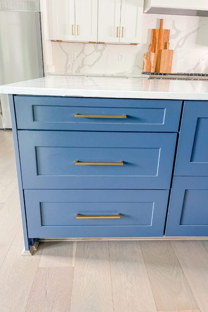 Gold brass hardware with navy blue cabinet