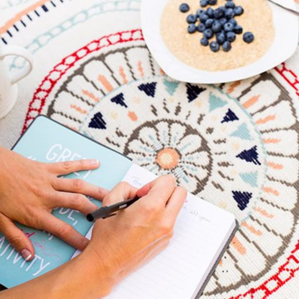Woman writing in bible journal.